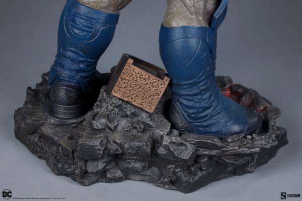 Darkseid DC Comics Maquette from Sideshow Collectibles. Close-up of a collectible superhero statue showing blue boots on a rocky base with a small plaque.