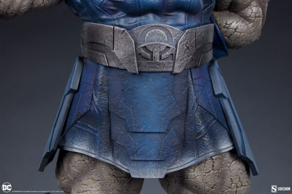 Darkseid DC Comics Maquette from Sideshow Collectibles. Close-up view of a textured Superman costume with a focus on the belt and suit patterns, against a grey background.