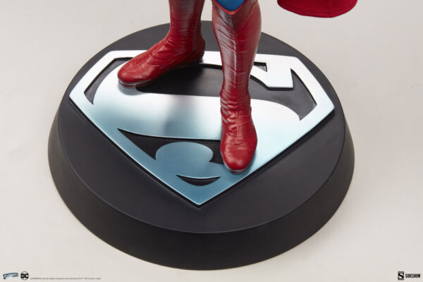 Superman: The Movie Premium Format™ Figure from Sideshow Collectibles and DC Comics. Close-up of a Superman statue feet standing on the iconic 'S' shield logo base.