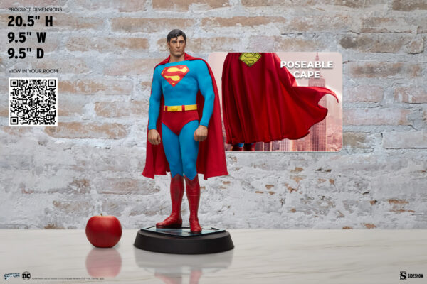 Superman: The Movie Premium Format™ Figure from Sideshow Collectibles and DC Comics. A lifelike collectible figure of a superhero with a blue suit, red cape, and an iconic emblem on the chest, displayed with product dimensions and a poseable cape feature.