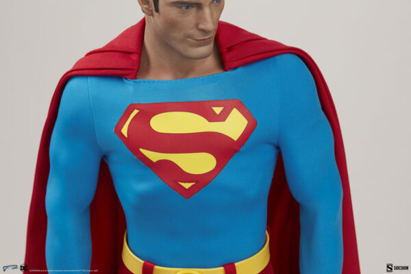 Superman: The Movie Premium Format™ Figure from Sideshow Collectibles and DC Comics. Close-up image of a Superman figure showcasing the classic blue costume with red cape and the famous 'S' shield on the chest.