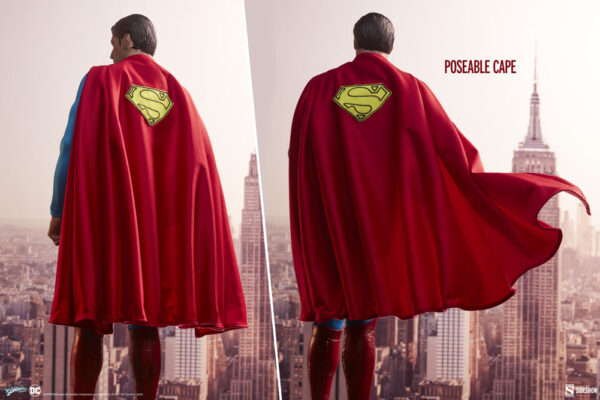 Superman: The Movie Premium Format™ Figure from Sideshow Collectibles and DC Comics. Image of a person with a Superman cape looking out over a city skyline, with one side of the cape blowing in the wind demonstrating its posability.