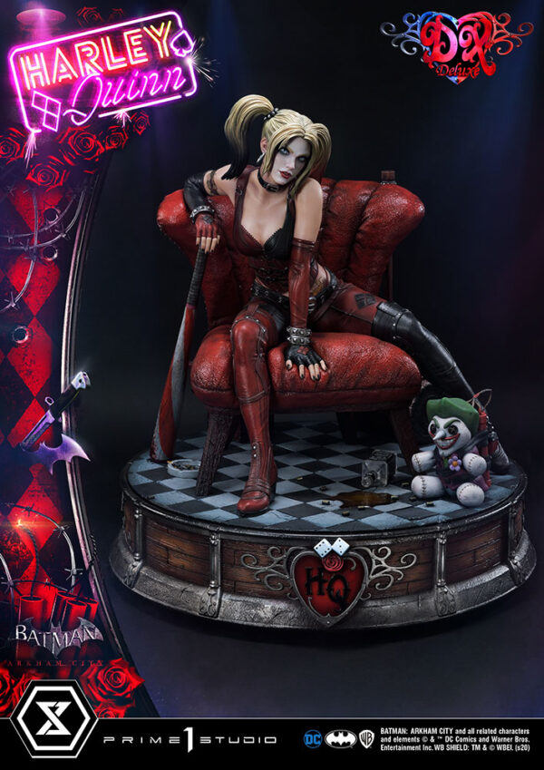 Harley Quinn Deluxe Batman Arkham City Statue Deluxe Version 1:3 Scale Statue from DC Comics and Prime 1 Studio. A highly detailed collectible figure of Harley Quinn posed on a themed base, alongside a clown-themed toy, with neon-style branding and intricate costume details.