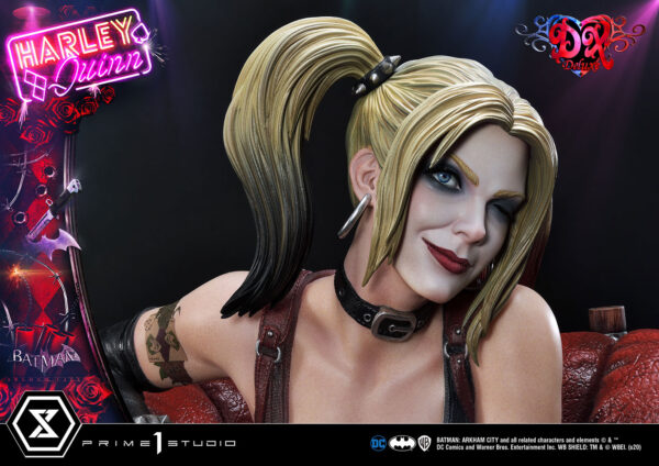 Harley Quinn Deluxe Batman Arkham City Statue Deluxe Version 1:3 Scale Statue from DC Comics and Prime 1 Studio. A close-up image of a Harley Quinn figure with detailed features, two-tone hair, and makeup, against a backdrop with her name in neon and references to Batman: Arkham City.