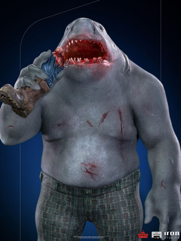 King Shark 1:10 Scale Statue from Iron Studios and DC Comics. An anthropomorphic shark character with human-like body and shark head, wearing pants and biting into a boot.