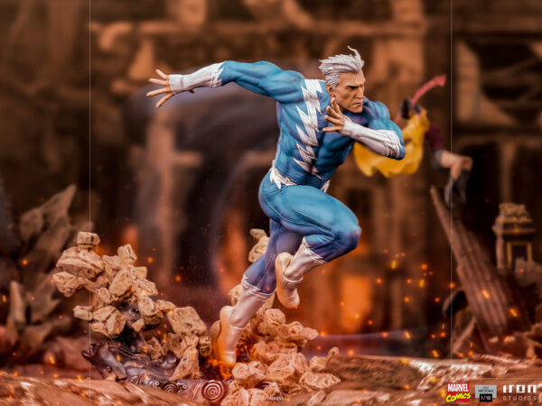 Marvel Quicksilver 1:10 scale statue from Iron Studios. A detailed action figure of a superhero with white hair and a blue costume, dynamically posed with an outstretched arm, amid a blurred background suggesting movement and a chaotic scene.