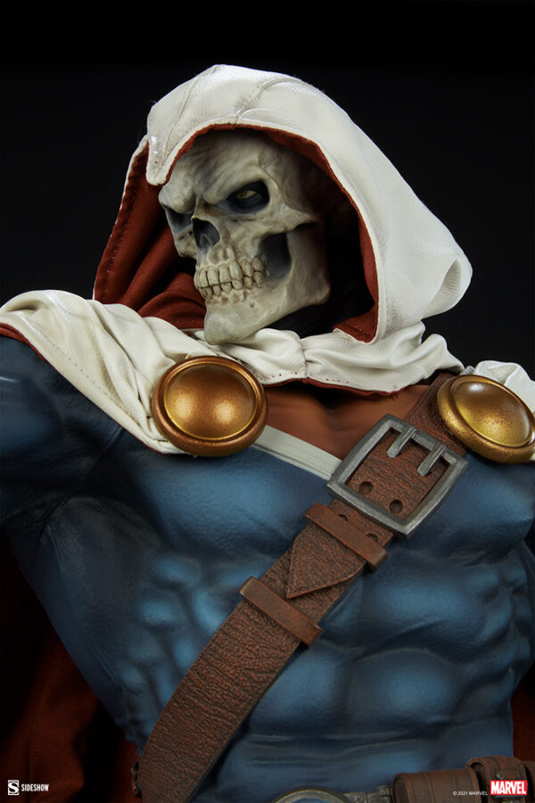 Marvel Taskmaster Premium Format Figure from Sideshow Collectibles. A close-up view of a collectible figure with a skull head, wearing a hooded cloak and a detailed costume, on a dark background.