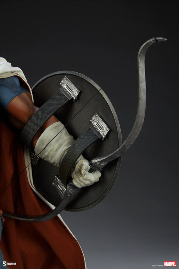 Marvel Taskmaster Premium Format Figure from Sideshow Collectibles. Close-up image of a superhero archer's arm with a bow, quiver, and arrows against a dark background, showcasing detailed costuming and props.