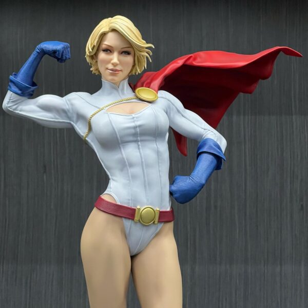 Power Girl Premium Format™ Figure from Sideshow Collectibles. A collectible figurine of a female superhero striking a powerful pose with a red cape and blue gloves.