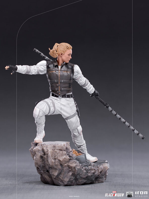 Yelena Belova 1:10 BDS Art Scale Statue from Marvel and Iron Studios. A collectible figurine in an action pose with a staff weapon, dressed in a white suit with a tactical vest, standing on a rocky base.