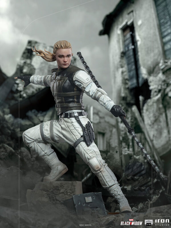 Yelena Belova 1:10 BDS Art Scale Statue from Marvel and Iron Studios. A figurine of a female warrior in a white combat suit with blonde hair positioned in a dynamic battle stance amidst a gray, rubble-filled landscape.