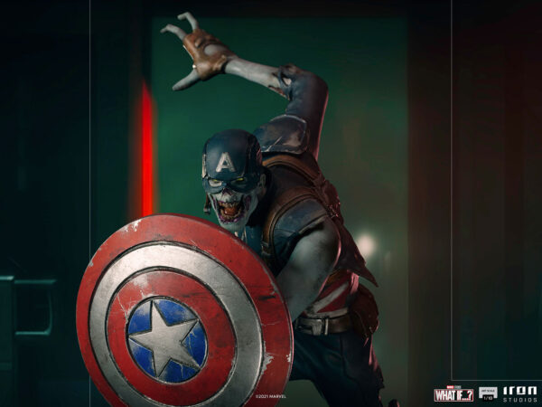 Zombie Captain America Art Scale 1:10 Statue. Zombie Captain America statue in a crouched pose, holding his iconic shield in a defensive stance. His skin appears decayed and blue-toned, with exposed muscles and torn uniform, embodying a grotesque and undead version of the classic Marvel superhero. The statue is set on a rugged, metallic base.