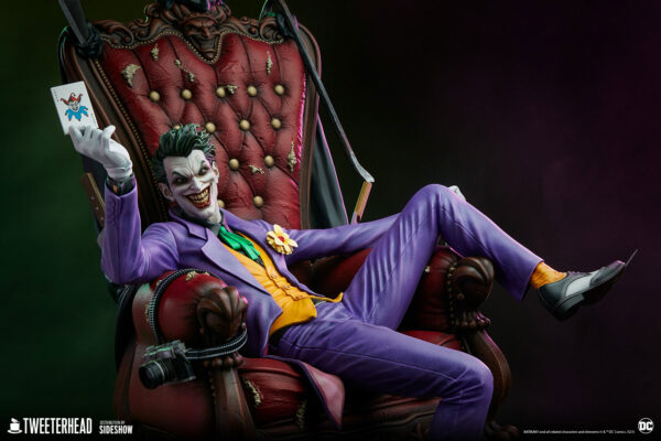 The Joker Deluxe Collector Edition Maquette from DC Comics and Tweeterhead. A figure of the Joker sitting on an ornate throne showing off a playing card, with a mischievous grin, in a purple suit and green vest.