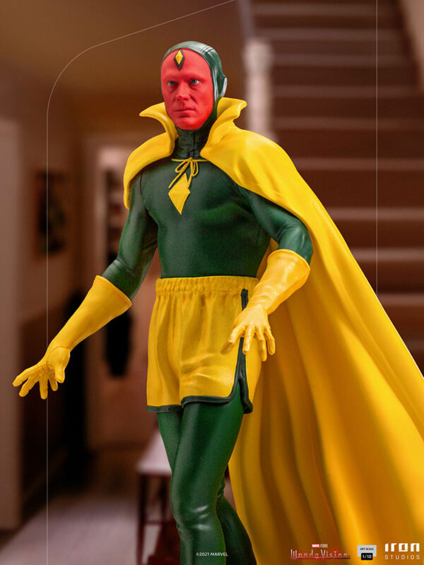 Vision Halloween Version WandaVision Art Scale 1:10 Statue from Marvel and Iron Studios. A figure dressed in a classic superhero costume with a red headpiece, yellow cape, and green suit standing inside a house.